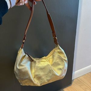 KATE SPADE shinny gold shoulder bag with brown leather strap.